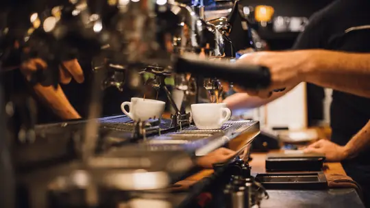 Barista preparando café em máquina de espresso